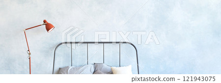 Minimalist bedroom with metal bed frame, gray bedding, red floor lamp, light 121943075