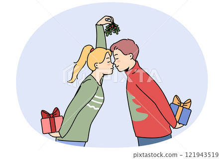 Christmas couple with gift boxes kisses and holds fir cones in hands and exchange new year presents Christmas couple with gift boxes kisses and holds fir cones in hands and exchange new year presents 121943519