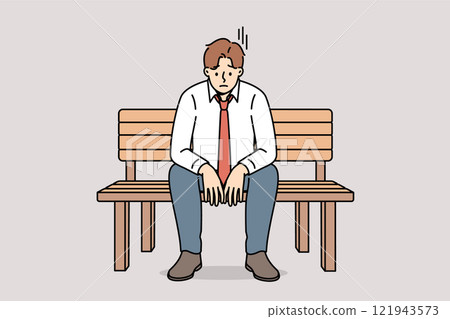 Depressed business man sitting on park bench and feeling sad about financial problems 121943573