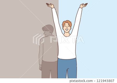 Happy man celebrating recovery from depression and restoration, standing near sad shadow 121943807