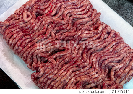 Fresh raw minced meat on paper, pork, beef, forcemeat close-up isolated on white background, top view. 121945915
