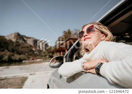 Woman in a Car Window Smiling and Looking Away Woman in a Car Window Smiling and Looking Away 121946472