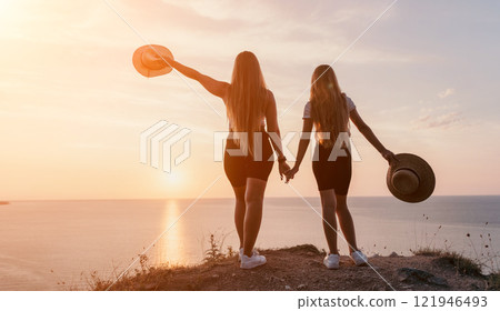 Silhouettes of Two Women at Sunset 121946493