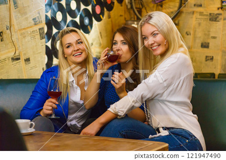 Girls in club talking drinking alcohol Girls in club talking drinking alcohol 121947490