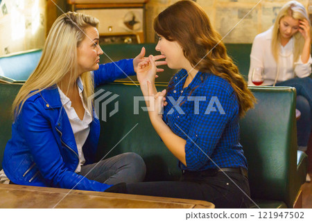 Women gossiping about friend Women gossiping about friend 121947502