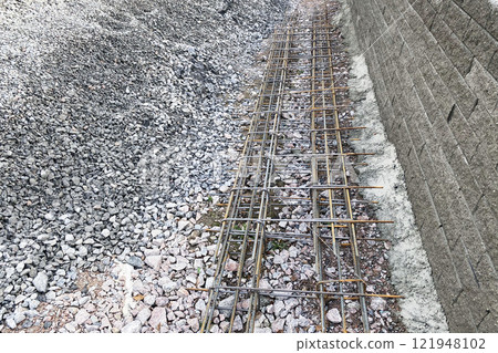 metal reinforcement fastened with wire lies on an embankment of crushed stone for pouring concrete 121948102