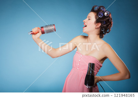 girl with curlers in hair holds hairdreyer girl with curlers in hair holds hairdreyer 121948165