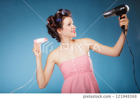 girl with curlers in hair holds hairdreyers girl with curlers in hair holds hairdreyers 121948168