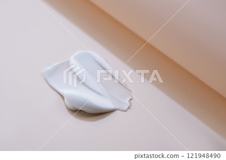 The texture of cosmetic cream on a beige background. The texture of cosmetic cream on a beige background. 121948490