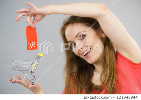 Girl with shopping cart and sale tag. 121948944