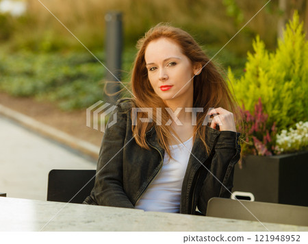 Fashion model in jeans jacket relaxing outdoor 121948952