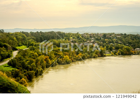 The fortress perched on Petrovaradin Hill watches over the city, while the charming streets and modern buildings of Novi Sad are spread out, creating a perfect blend of history and contemporary life 121949042
