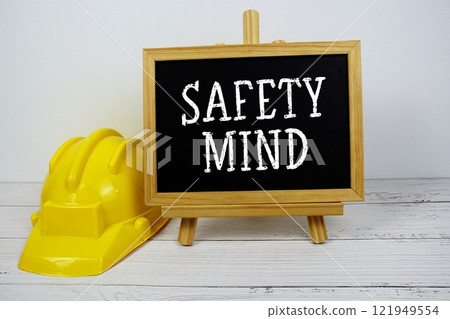 Safety Mind text on blackboard with safety helmet on wooden background 121949554