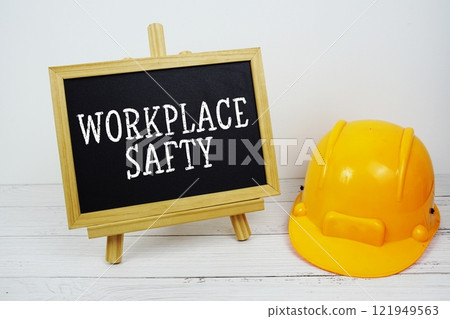 Workplace Safety text on blackboard with safety helmet on wooden background Workplace Safety text on blackboard with safety helmet on wooden background 121949563