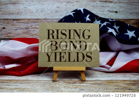 Rising Bond Yields text messege with USA flag on wooden background Rising Bond Yields text messege with USA flag on wooden background 121949728