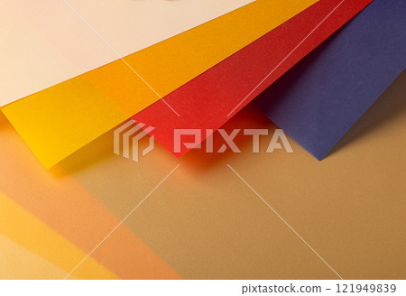 Layered paper background with semi transparent blue, red, yellow, orange, and beige sheets. Warm 121949839
