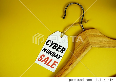 Cyber Monday Sale on price tag with wooden clothes hanger top view on yellow background Cyber Monday Sale on price tag with wooden clothes hanger top view on yellow background 121950216
