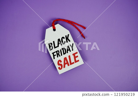 Black Friday Sale on price tag with wooden clothes hanger top view on purple background 121950219
