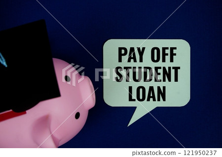 Pay off student loan text on speech bubble with piggy bank and graduation cap top view on navy blue background 121950237