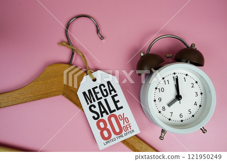 Mega Sale 80% on price tag with wooden clothes hanger and alarm clock top view on pink background 121950249