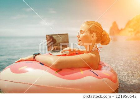 Woman laptop sea. Freelancer woman in sunglases floating on an inflatable big pink donut with a laptop in the sea. People summer vacation rest lifestyle concept Woman laptop sea. Freelancer woman in sunglases floating on an inflatable big pink donut with a laptop in the sea. People summer vacation rest lifestyle concept 121950542