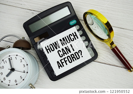 How much can I afford? text message on sticky note with magnifying glass, alarm clock and calculator on wooden background How much can I afford? text message on sticky note with magnifying glass, alarm clock and calculator on wooden background 121950552