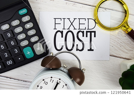 Fixed Cost text message with calculate, alarm clock and magnifying glass on wooden background 121950641
