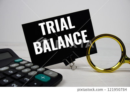 Trial Balance text message with calculate and magnifying glass on wooden background 121950784