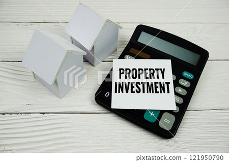 Property Invesment text message with calculate and house model on wooden background 121950790