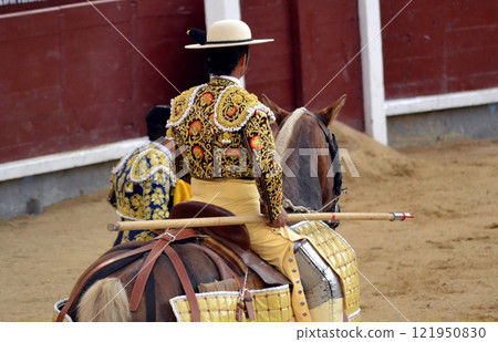 Traditional bullfighting scene with horse and matador in ornate costume. Tauromaquia. Spanish traditions Traditional bullfighting scene with horse and matador in ornate costume. Tauromaquia. Spanish traditions 121950830