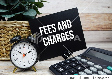 Fee and Charges text with alarm clock and calculator on wooden background, Business concept 121950935