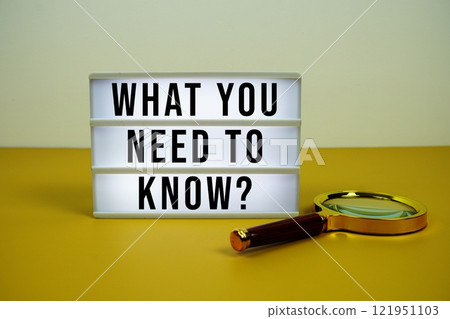 What You Need To Know? text on LED lightbox with magnifying glass on yellow background 121951103