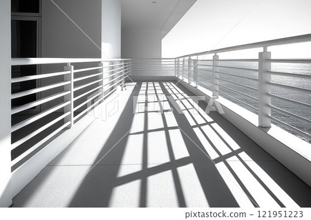 White balcony overlooking the sea casting shadows on sunny day 121951223