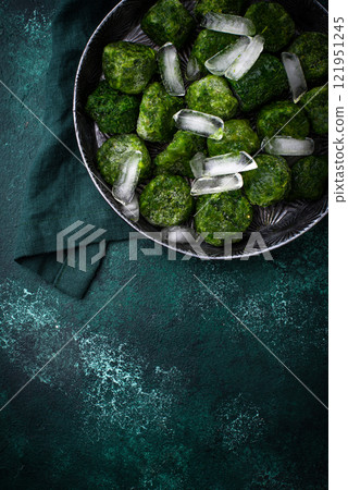 Frozen spinach green cubes in bowl 121951245