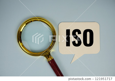 ISO text on speech bluble with magnifying glass top view on blue background ISO text on speech bluble with magnifying glass top view on blue background 121951717
