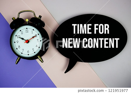 Time For New Content text on speech bubble with alarm clock top view on purple geometric background Time For New Content text on speech bubble with alarm clock top view on purple geometric background 121951977