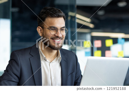 Successful businessman close-up at workplace working with laptop. Man in business suit reading and preparing online presentation. Mature boss looking at laptop screen. 121952188