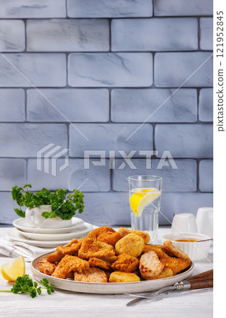 fried chunks, bites, tenders, nuggets on a plate 121952845