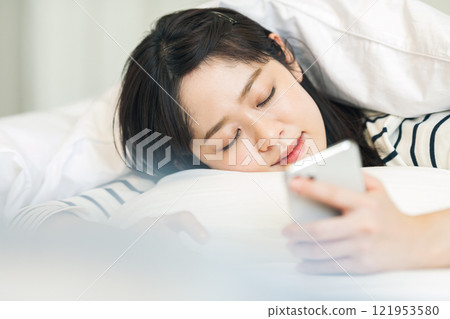 A woman who fell asleep with a smartphone 121953580