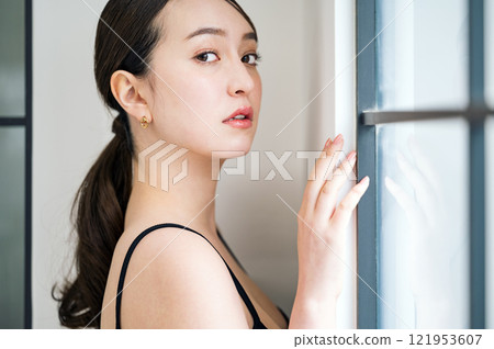 穿著黑色吊帶背心的年輕女子的肖像 穿著黑色吊帶背心的年輕女子的肖像 121953607