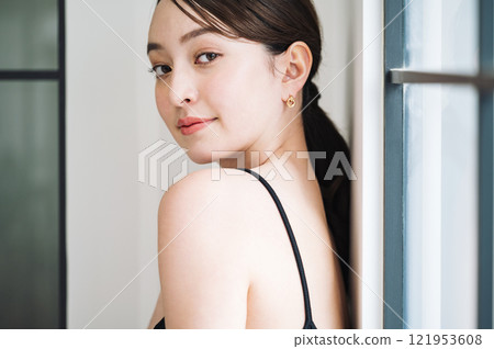 穿著黑色吊帶背心的年輕女子的肖像 121953608