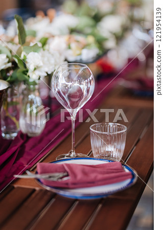 Elegant wine glass and water glass on a rustic table, perfect for fine dining and event settings Elegant wine glass and water glass on a rustic table, perfect for fine dining and event settings 121954139