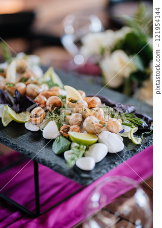 Elegant escargot dish with fresh herbs, lemon, and lime on a slate platter for gourmet dining Elegant escargot dish with fresh herbs, lemon, and lime on a slate platter for gourmet dining 121954144