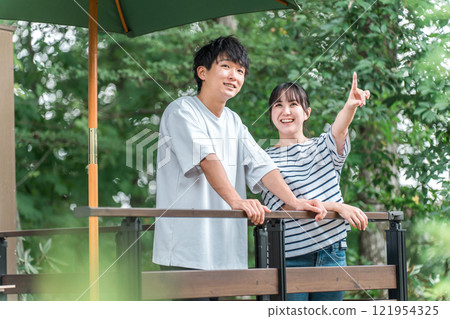 假期和暑假期間，男人和女人在綠色植物中提神（度假村、露台、養老金、別墅、戶外） 121954325