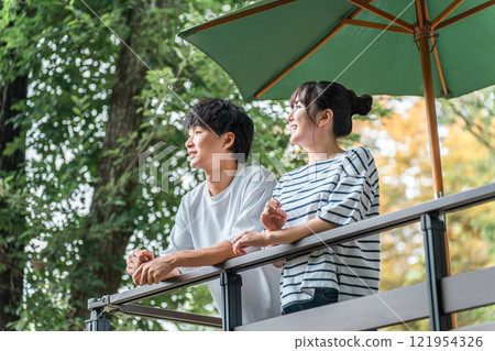 Men and women refreshing in the greenery on holidays and summer vacations (resort, terrace, pension, cottage, outdoors) 121954326