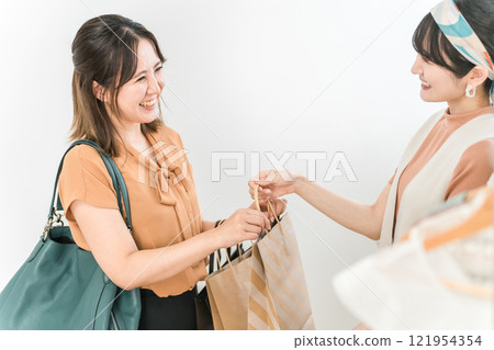 一名女性顧客在服飾店/雜貨店收銀台領取商品 一名女性顧客在服飾店/雜貨店收銀台領取商品 121954354