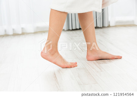 Young Asian woman walking barefoot on wooden floor. 121954564