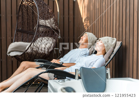 A couple of sauna lovers bathing in the open air while wearing sauna hats A couple of sauna lovers bathing in the open air while wearing sauna hats 121955423