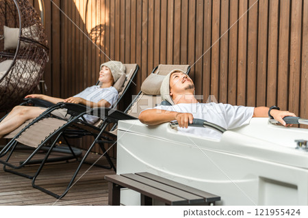 A couple of sauna lovers bathing in the open air while wearing sauna hats A couple of sauna lovers bathing in the open air while wearing sauna hats 121955424