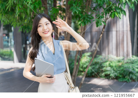 Businesswoman holding a tablet device in an office district 121955667
